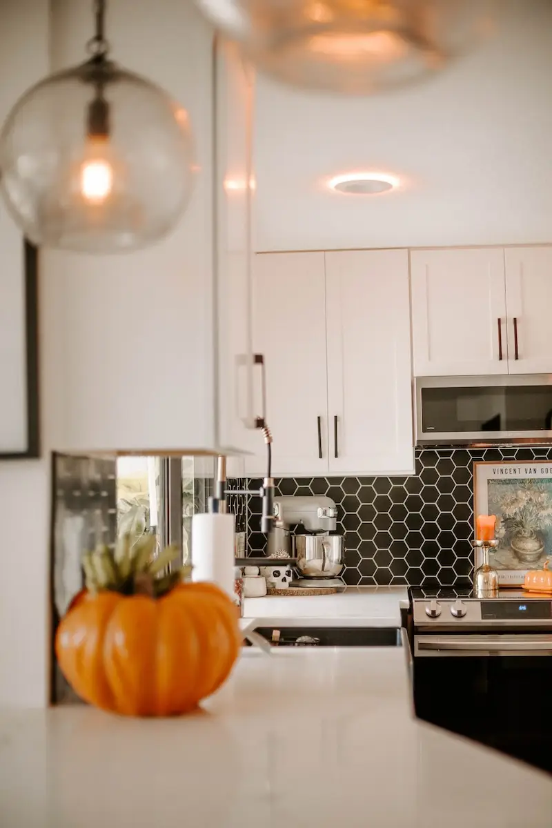 Modern kitchen with pumpkin decoration on counter.